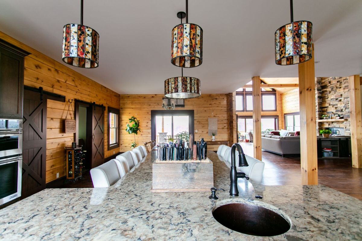 three hanging lights above light granite counter of island in kitchen