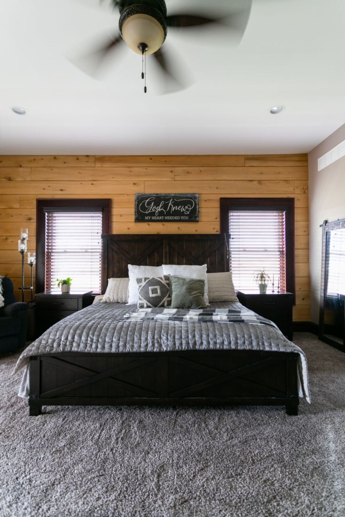 black footboard on bed in log cabin with dark blue striped bedding