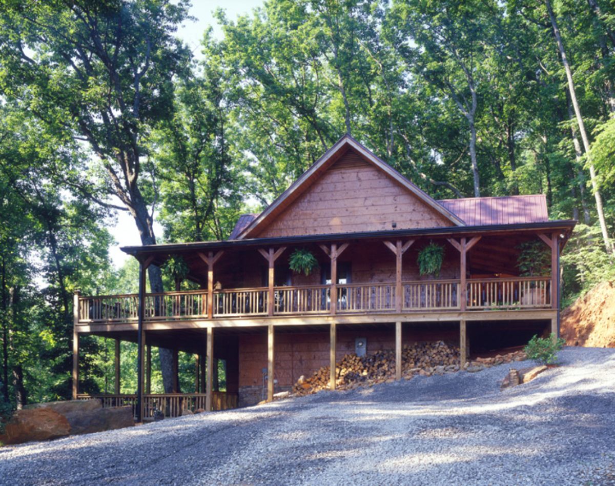 back of log cabin with covered porches and walkout basement