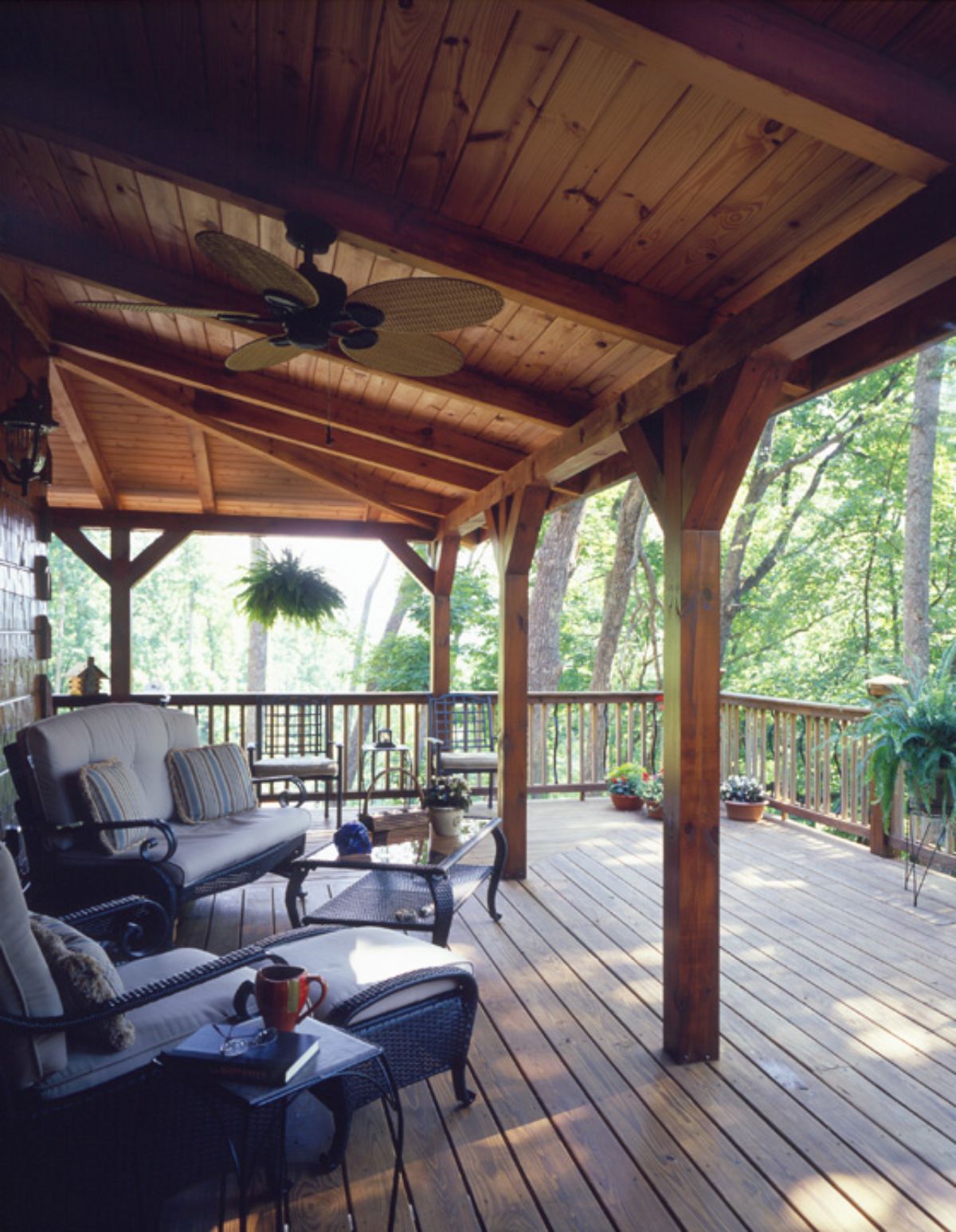 back porch of log cabin with chairs underneath the ceiling fans