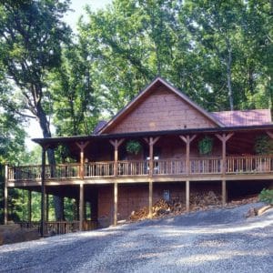 back of log cabin with covered porches and walkout basement