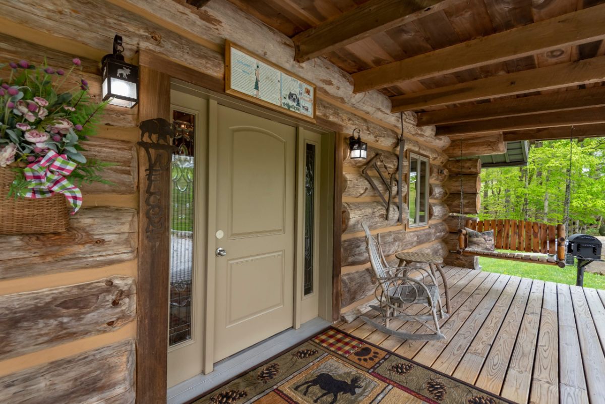 cream colored door on front of rustic log cabin with bear rug in front