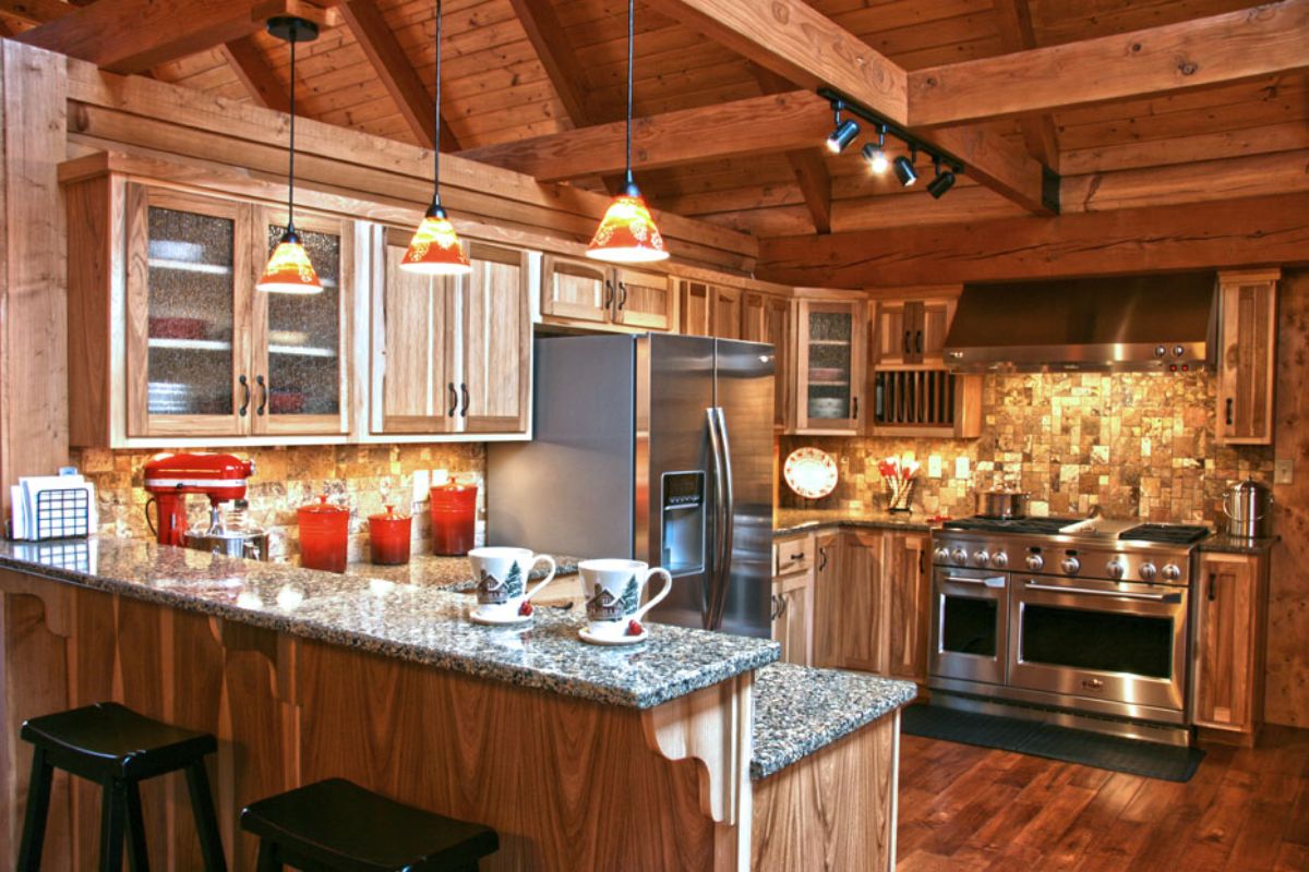 granite countertops in log cabin kitchen with stainless steel chefs stove in background