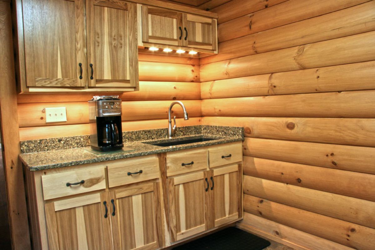 wet bar with coffee pot against log wood walls