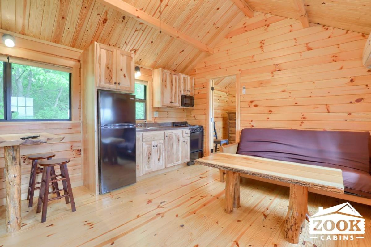 wood interior with purple cushion behind coffee table in main tiny home space