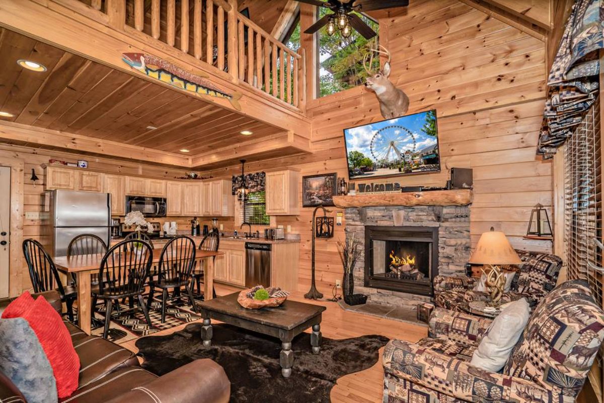 living room with lo walls stone fireplace and brown sofa in foreground