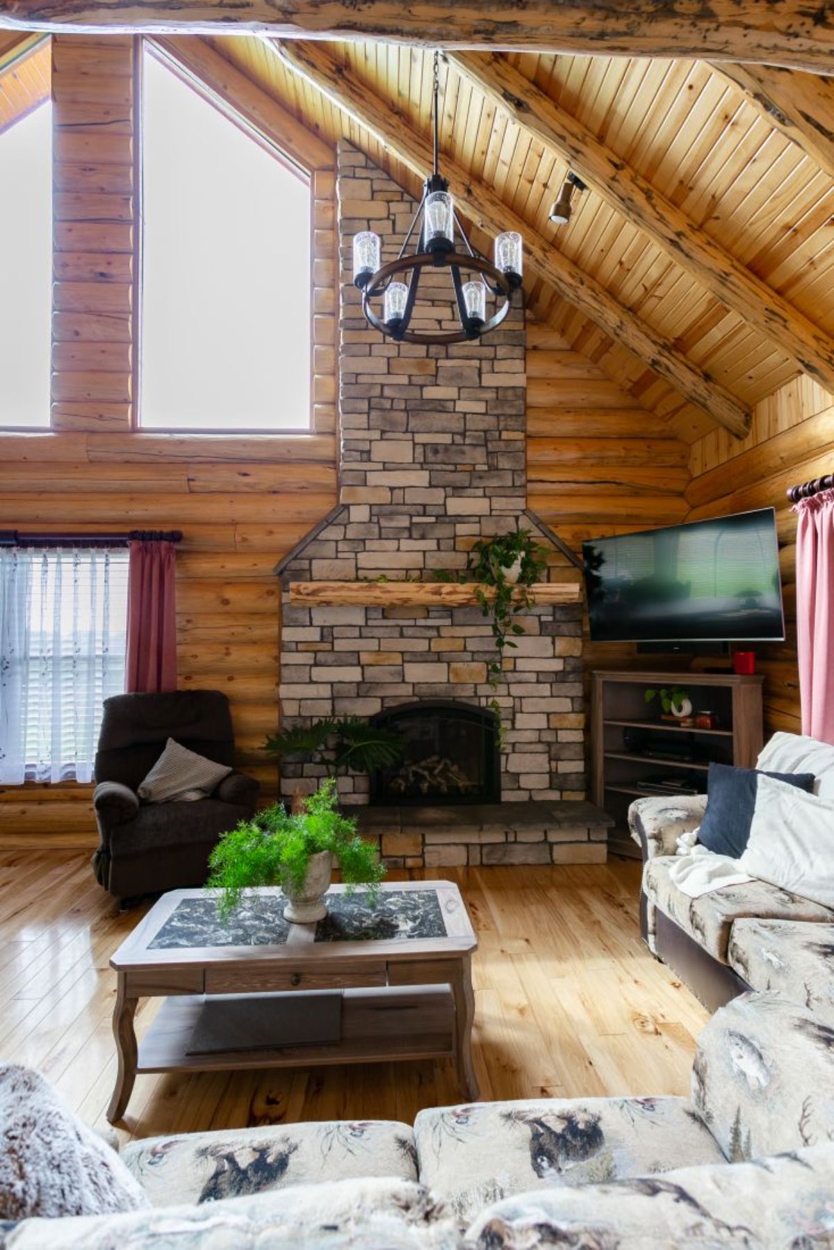 stone fireplace inside great room with sofa on right wall