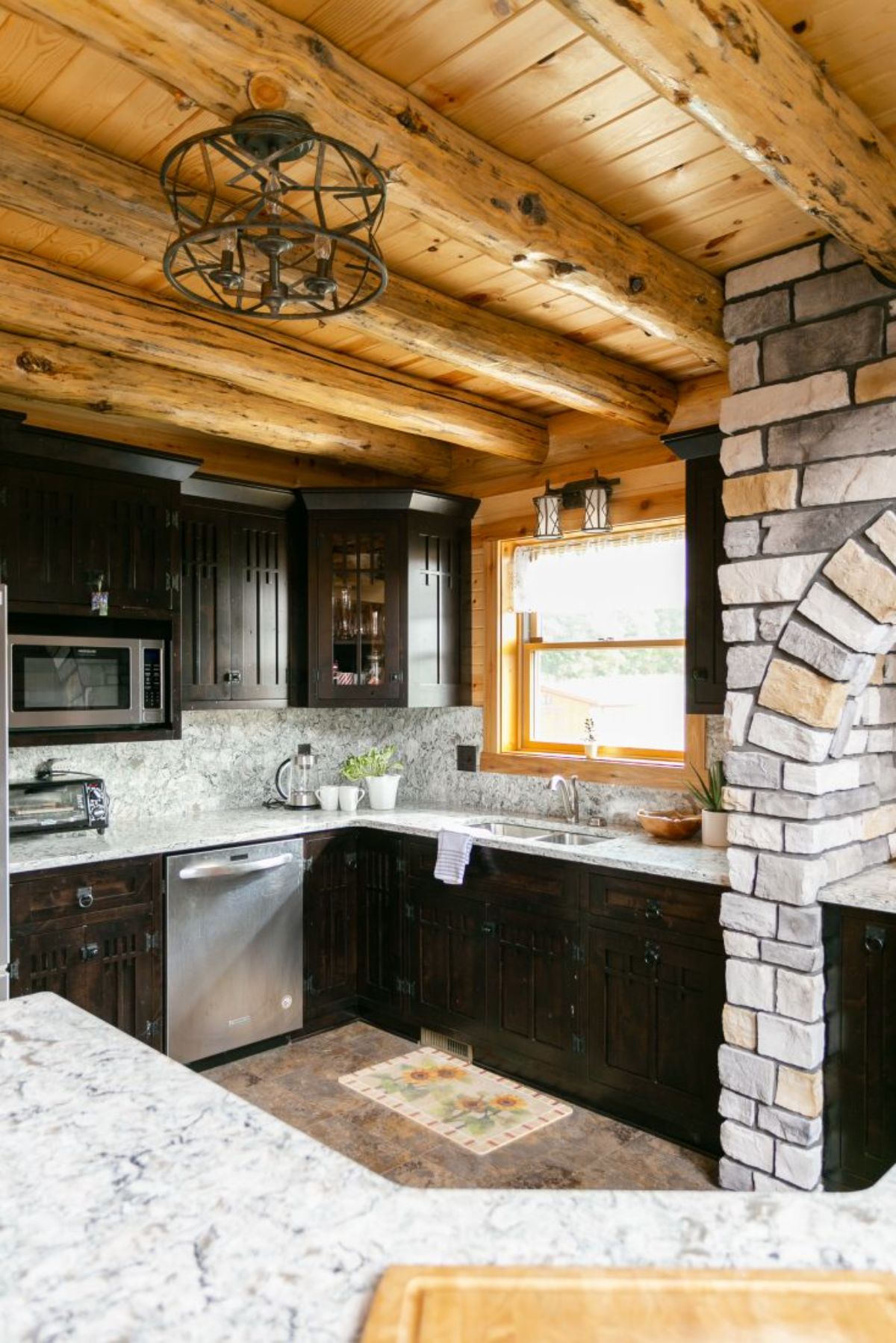 kitchen with black cabinets white countertops and stone work accents
