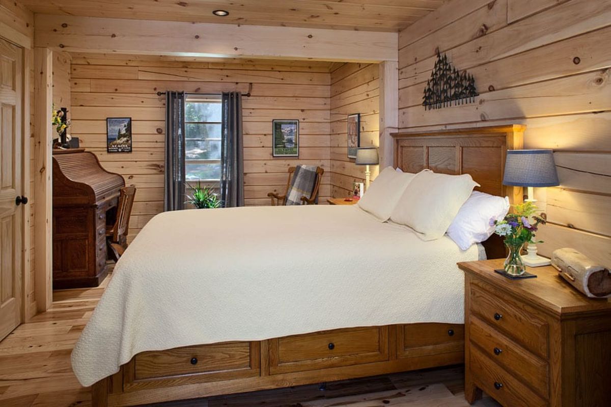 white bedding on captains bed made of wood in log cabin bedroom