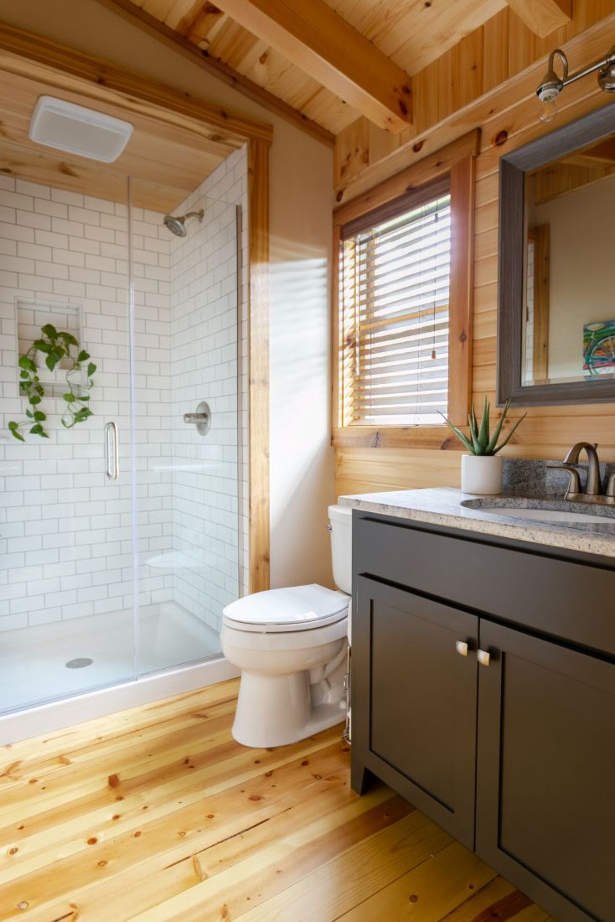 gray vanity base in bathroom with white shower stall in background