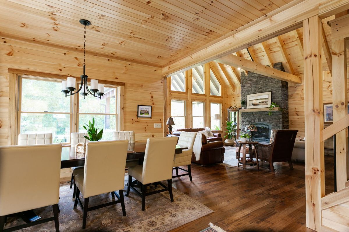 cream upholstery on chairs around dining table with living space and fireplace in background