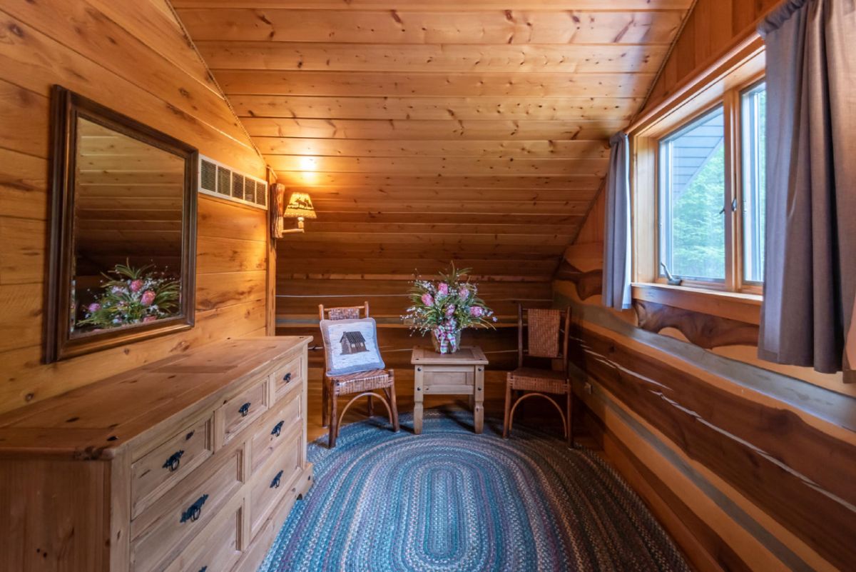 sitting room in loft bedroom of log cabin with oval blue rug