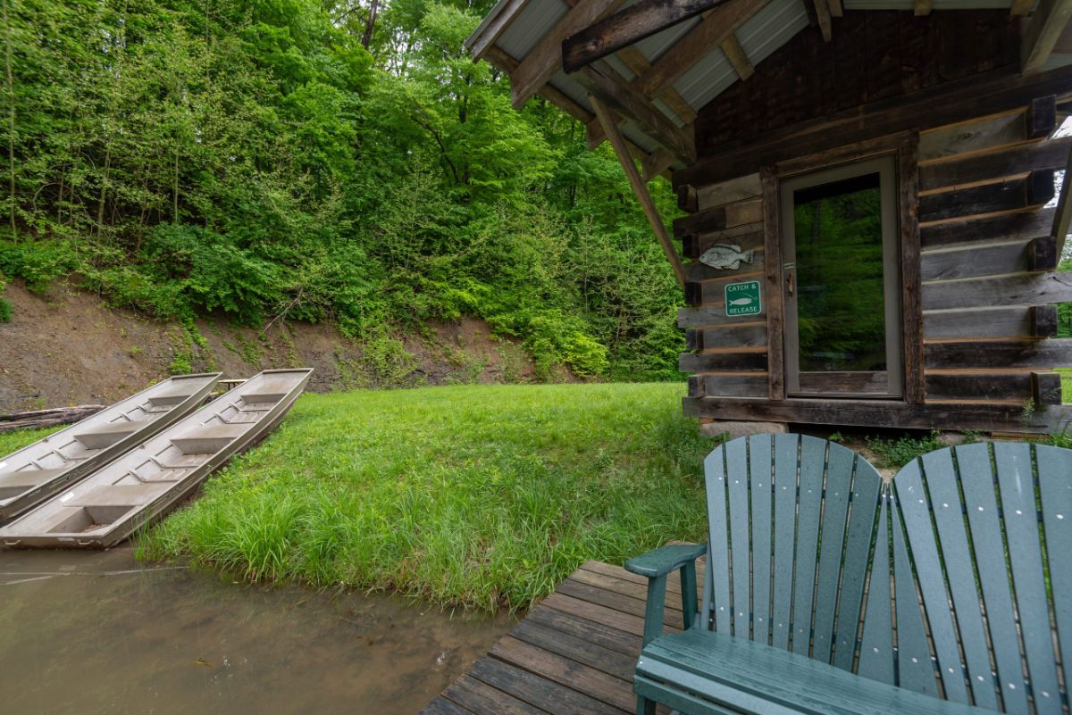 dock by lake with fishing hut by teal chairs