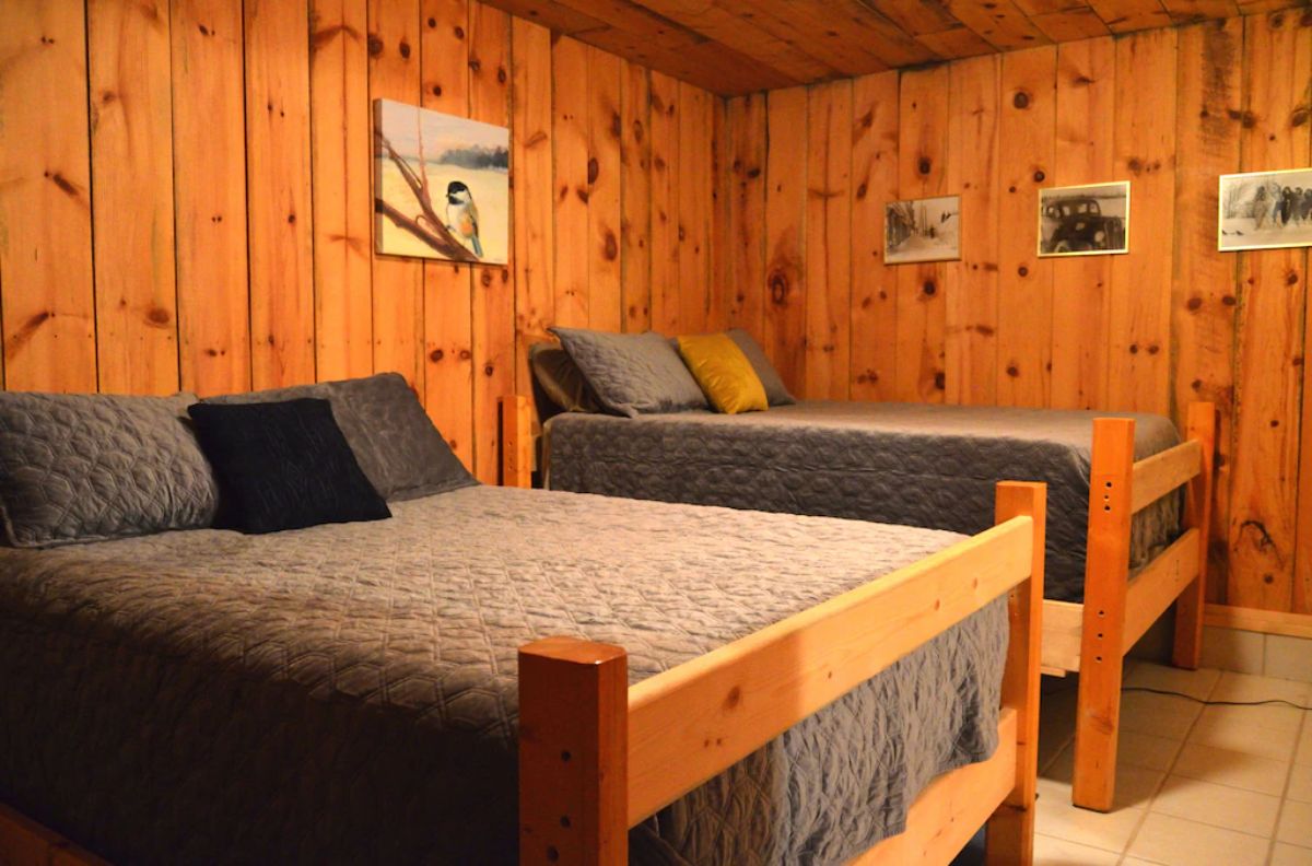 two beds with light blue bedding in log cabin bedroom