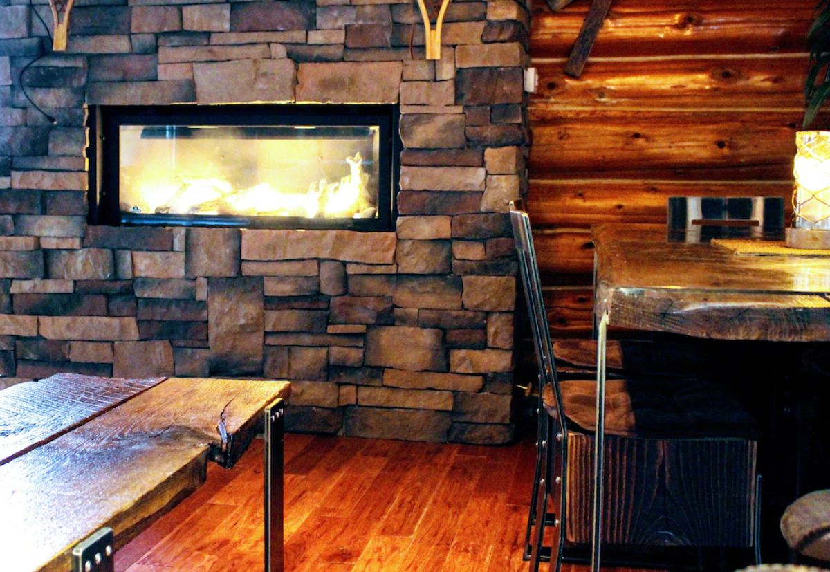 stone around fireplace against log cabin wall