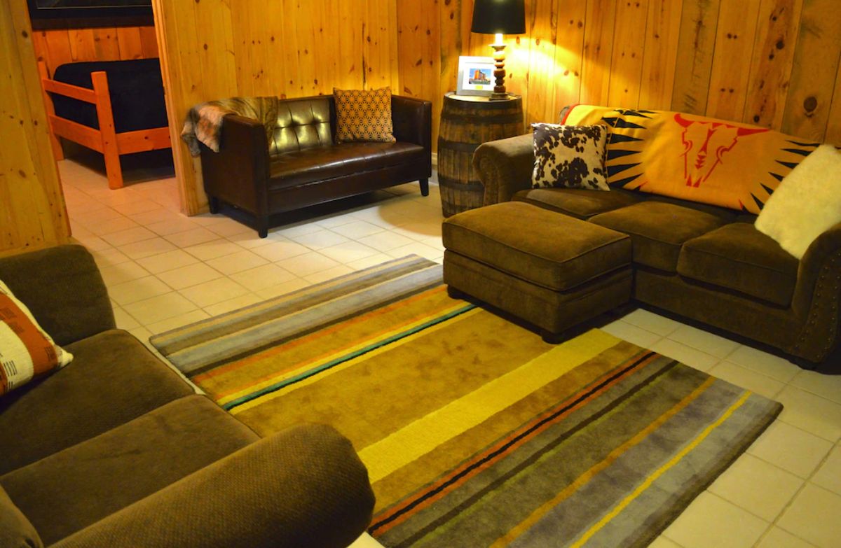 basement with sofas and rugs and open door to bedroom in background