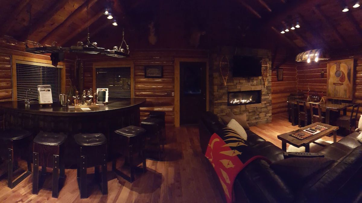 front door next to stone fireplace in log cabin