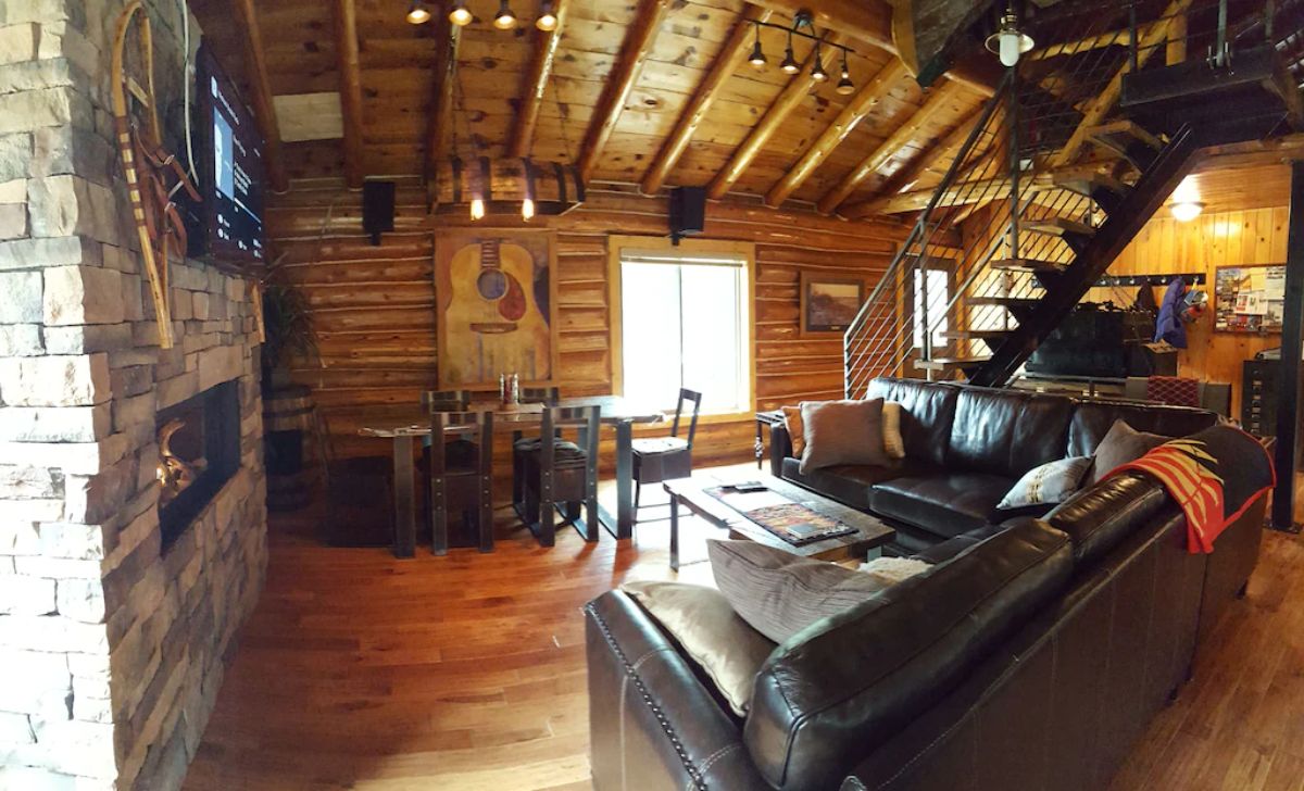 view across home with leather sofa in foreground and window by table in background