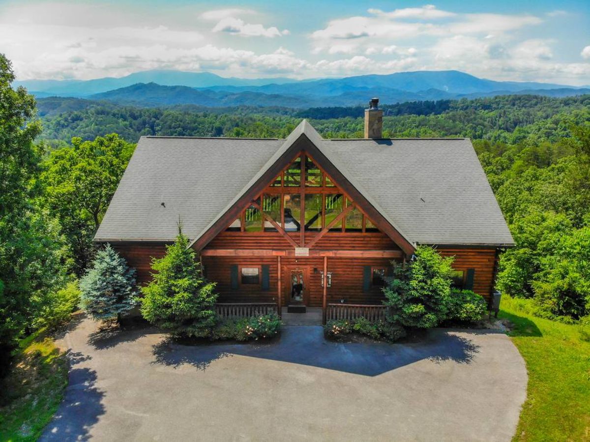 front of log cabin with view of mountains in the background