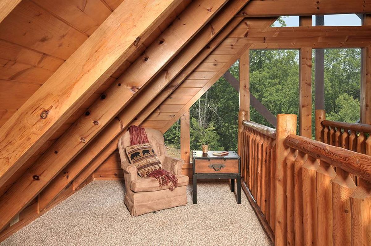 chair in nook by railing of loft in log cabin