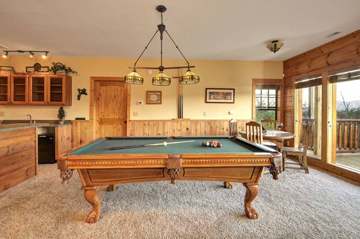 pool table with green top in middle of basement