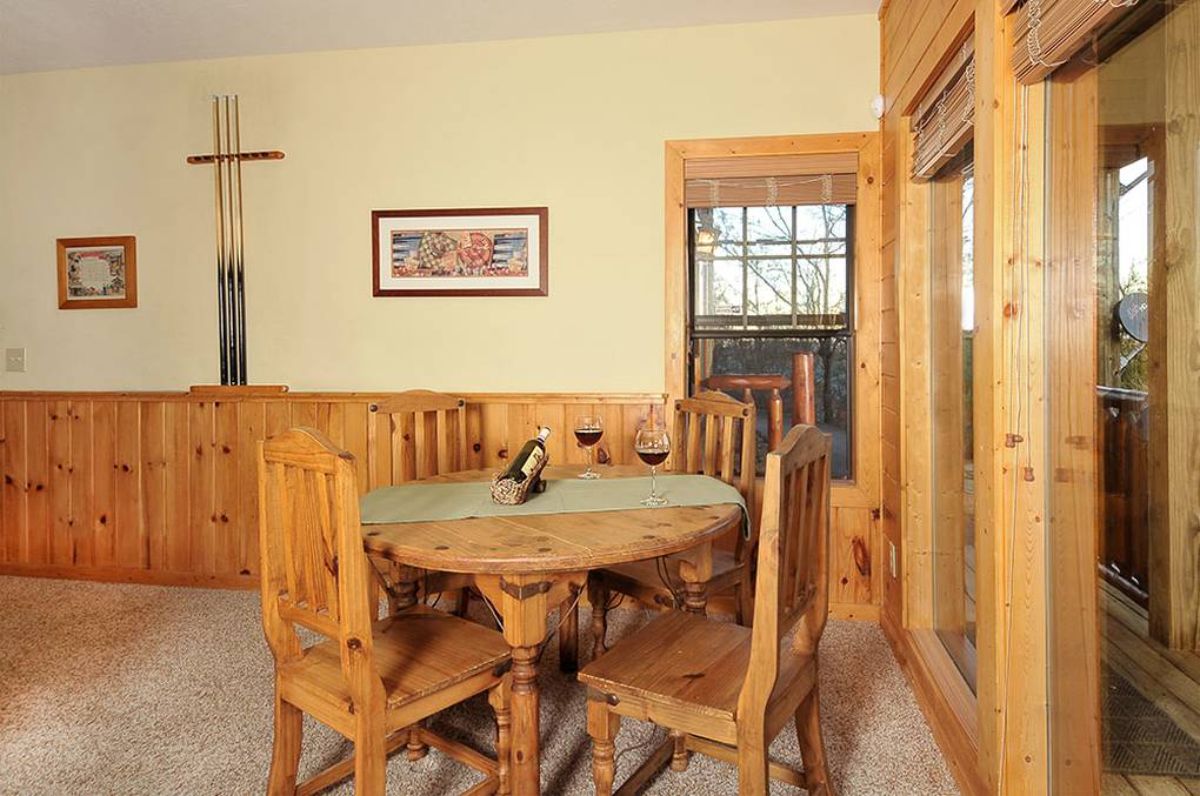 round wood table with wood chairs around it next to door