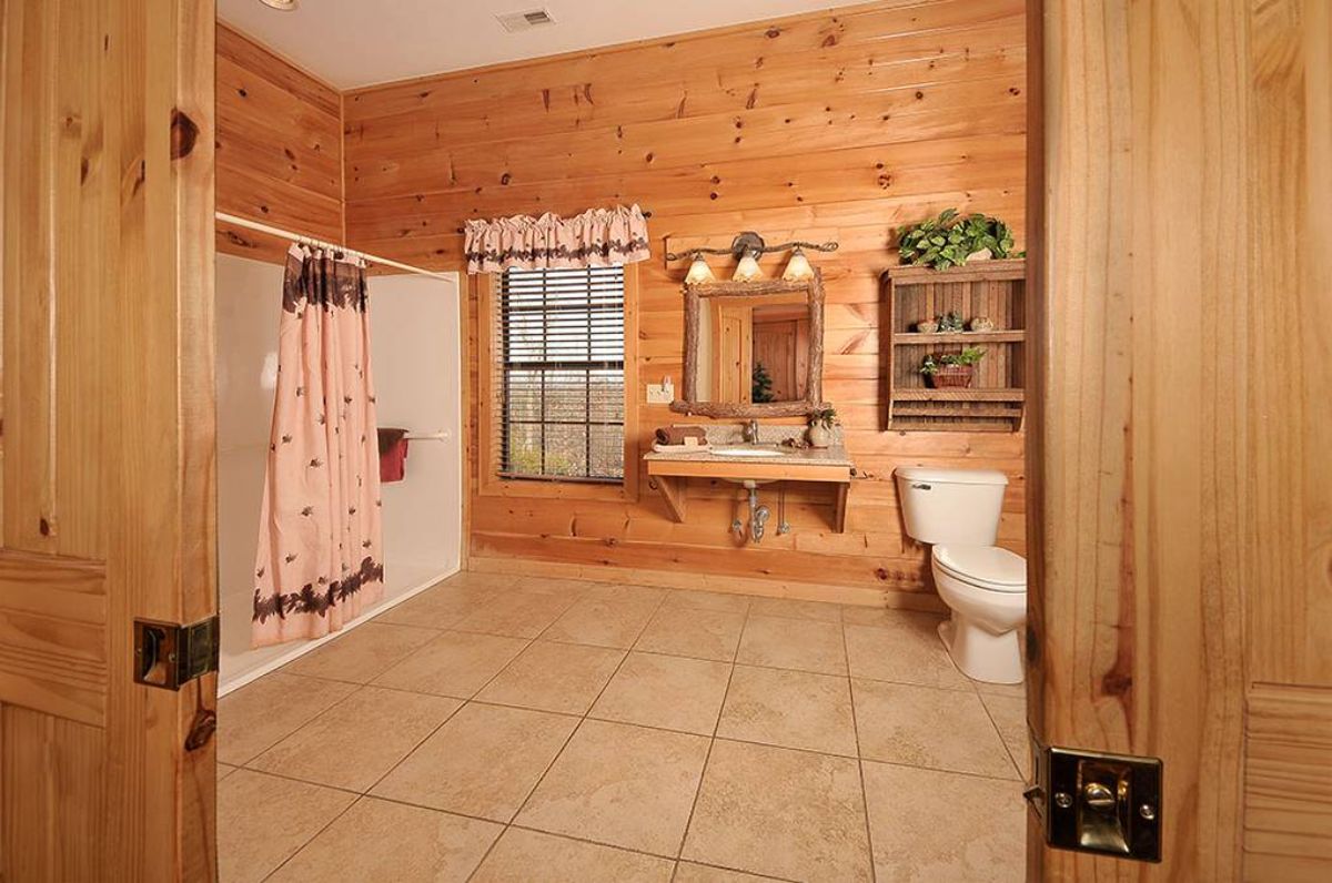 bathroom with brown tile floors and white shower to the left of image
