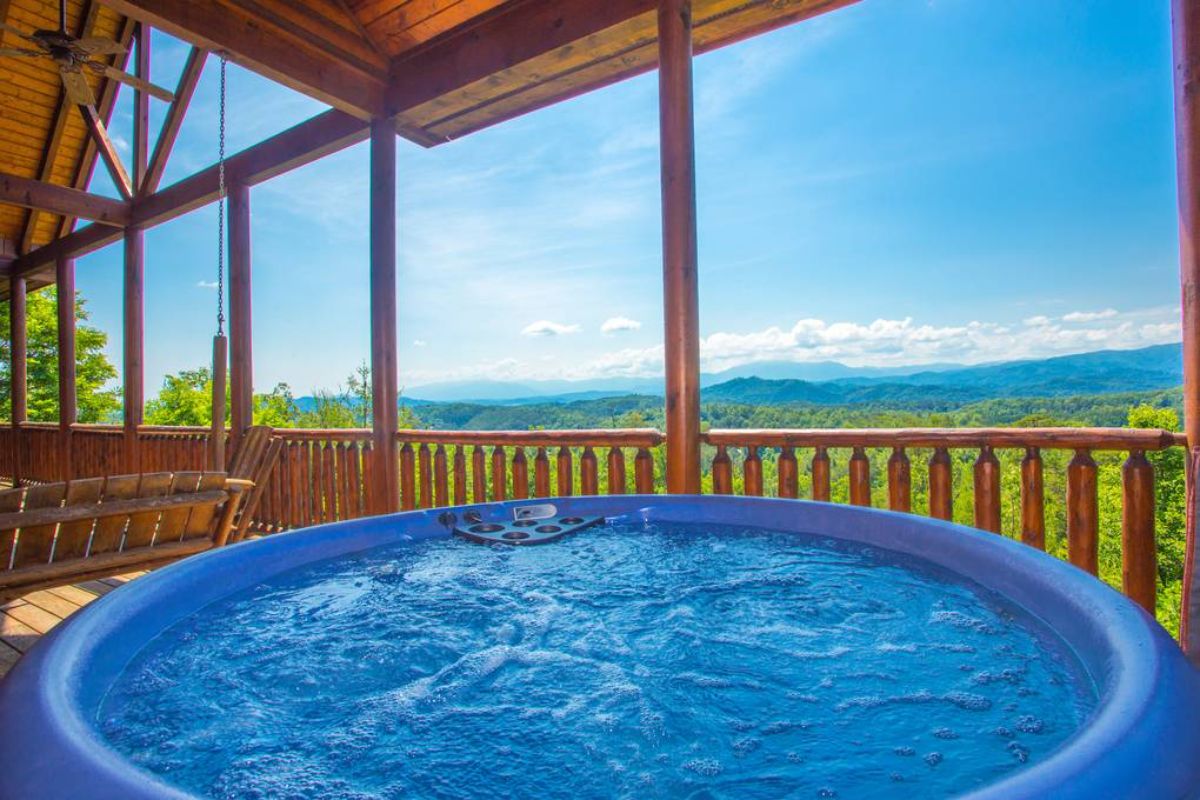 round hot tub on deck overlooking view of moutains