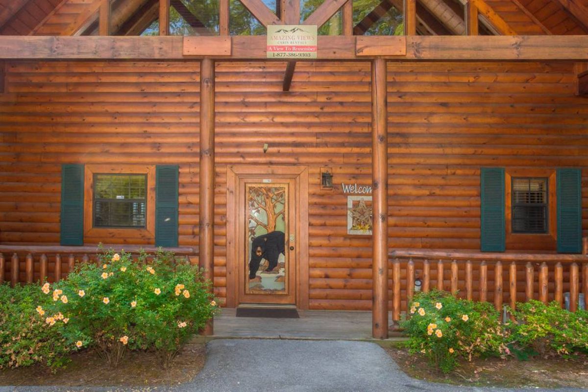 front door of log cabin with bear on door