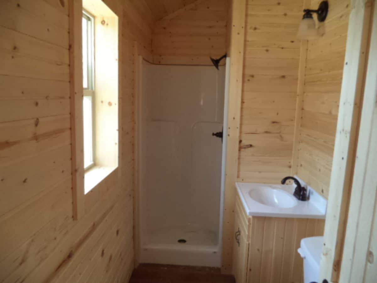 log cabin bathroom with white shower and vanity