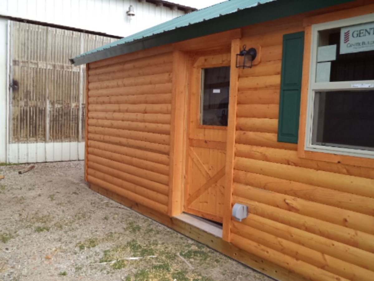 green trim on window and roof of log cabin