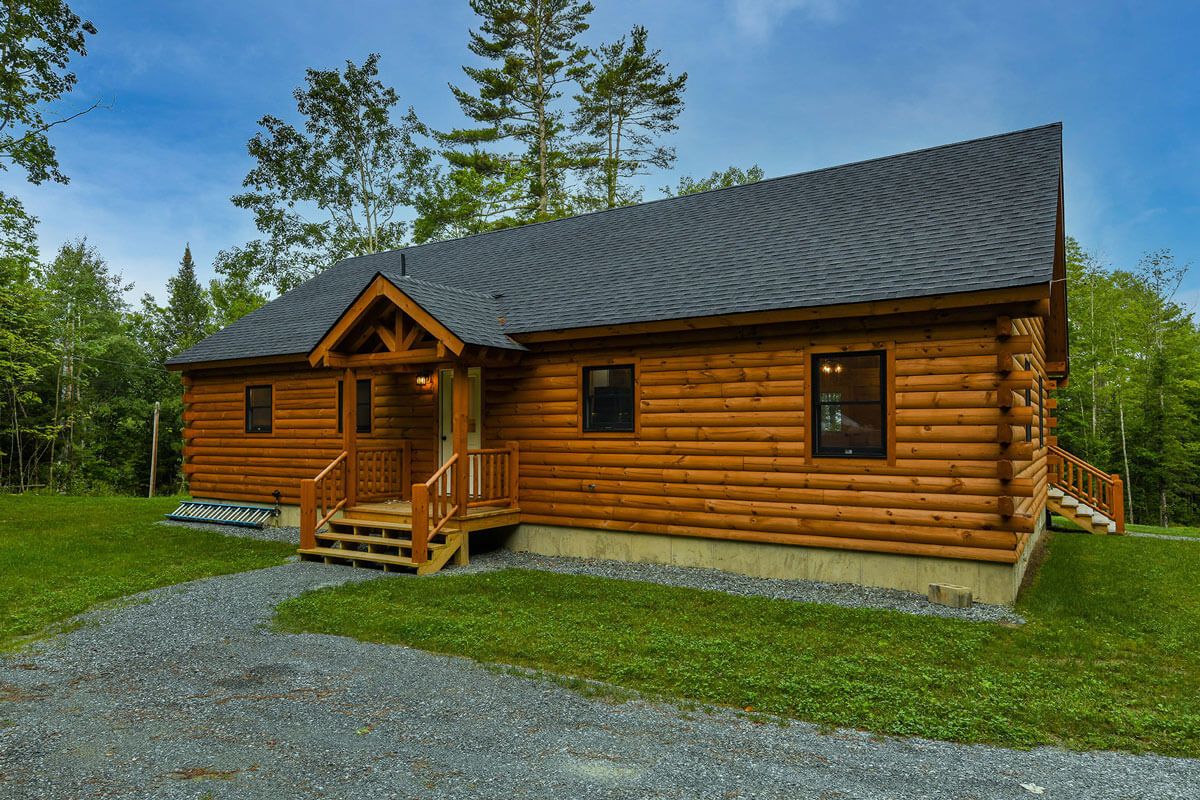 front of log cabin with green roof and small entryway