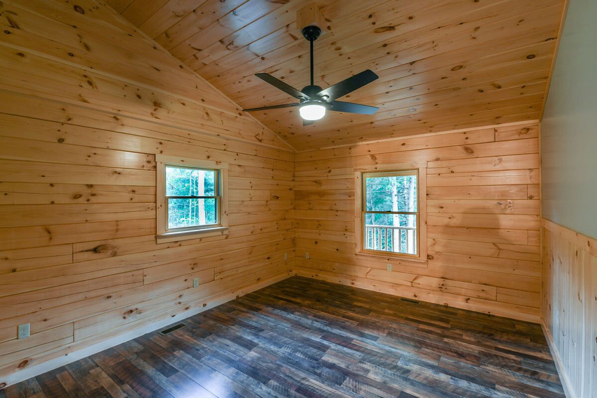 wood walls ceiling and floor of bedroom in log cabin