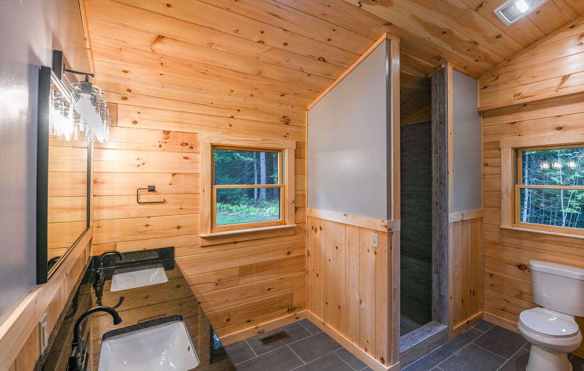 shower in corner of bathroom with black vanity