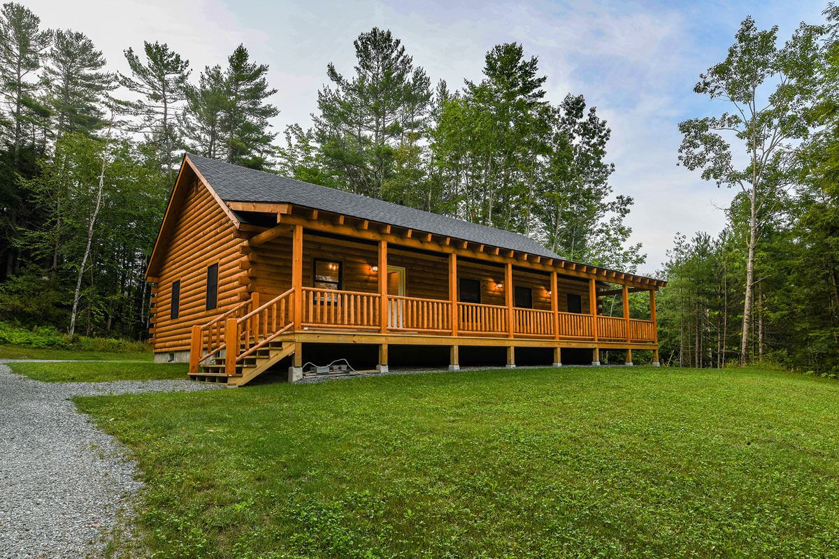 log cabin with porch along the back of the home