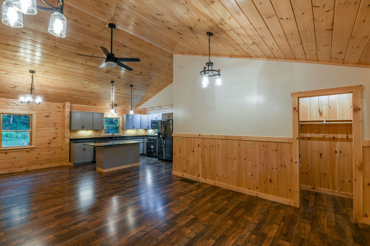 open room inside log cabin with half log walls