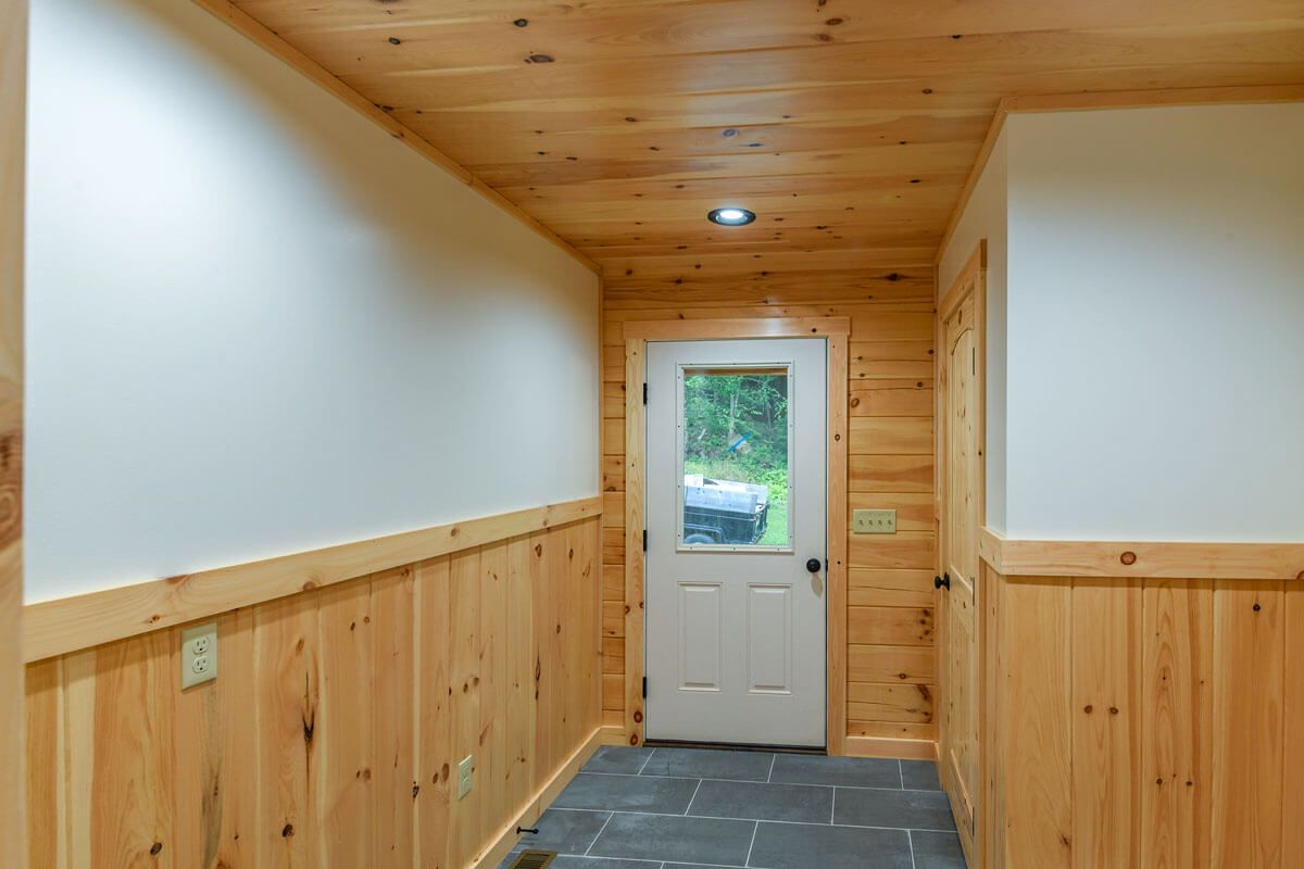 white door at back of room with wood wainscotting