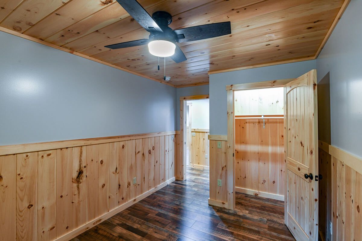 open door to the closet in log cabin bedroom