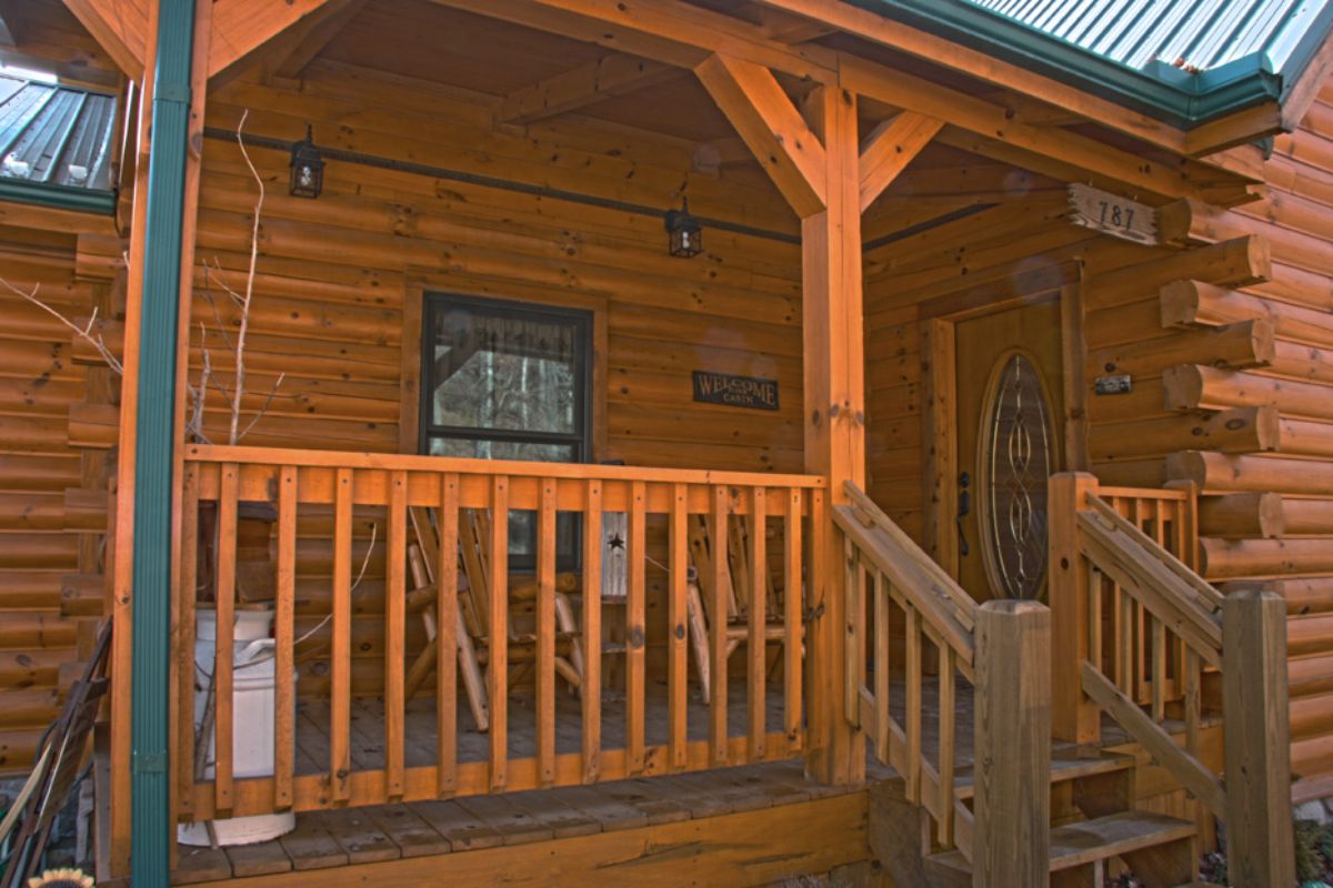 log cabin covered porch with wood railing