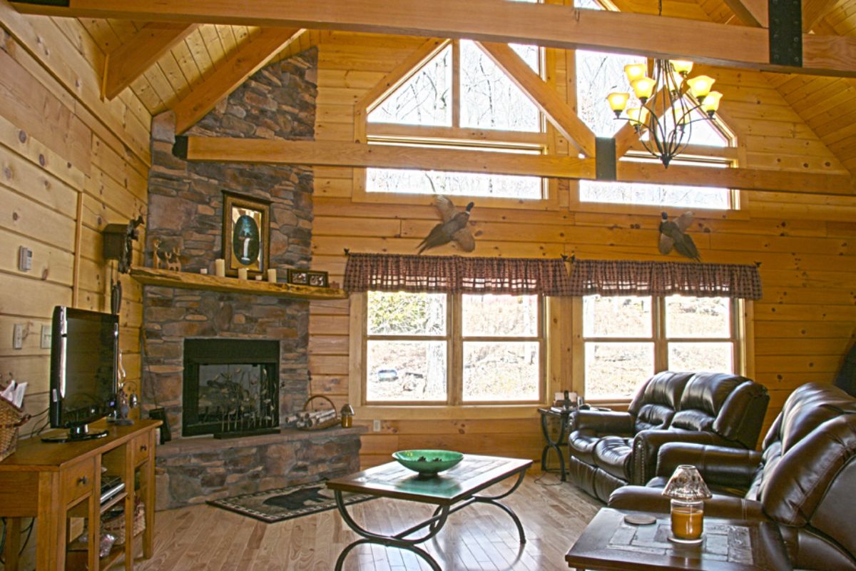 wall of windows along back of living area in log cabin