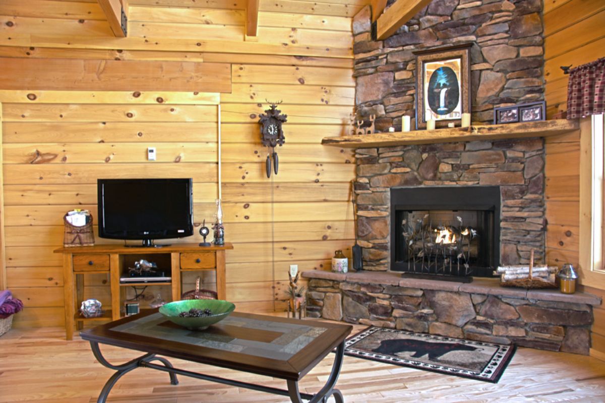 stone fireplace against light wood paneling