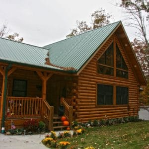 front porch on log cabin with covered porch and concrete walkway