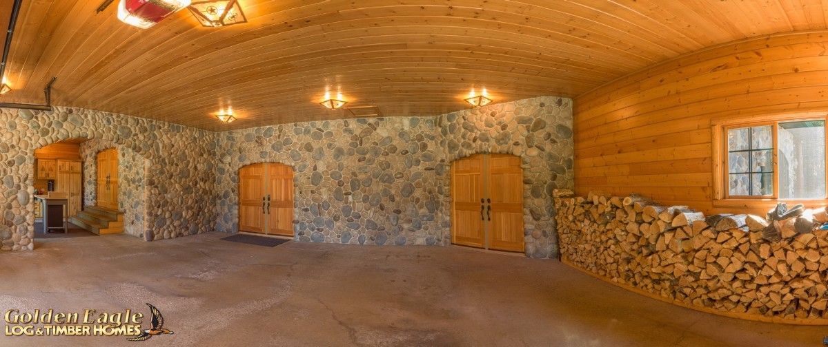stone wall at back of log cabin room with wall of logs on right