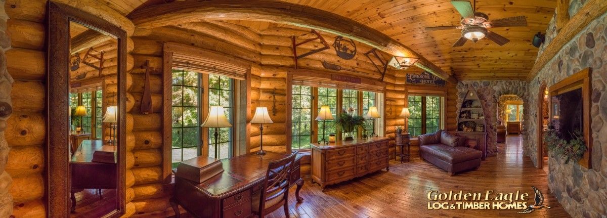 wall of windows below log cabin with stone on right side