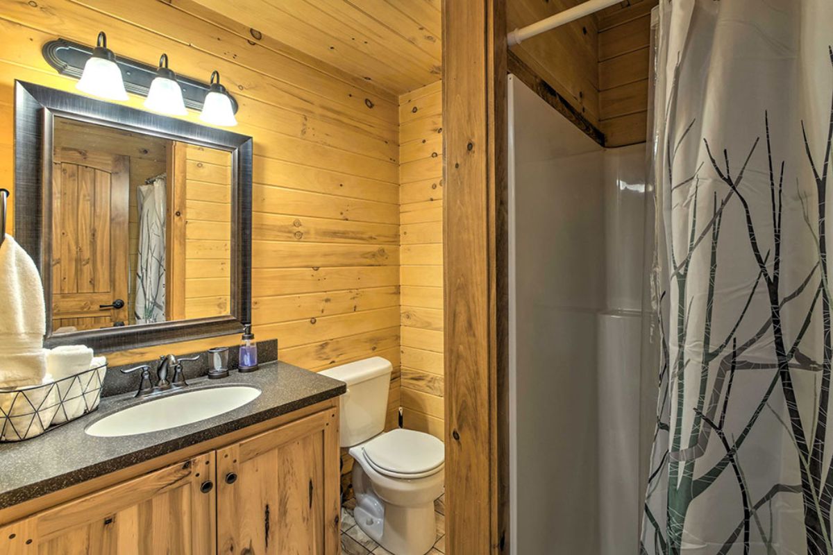 white shower curtain with tree design in log cabin bathroom