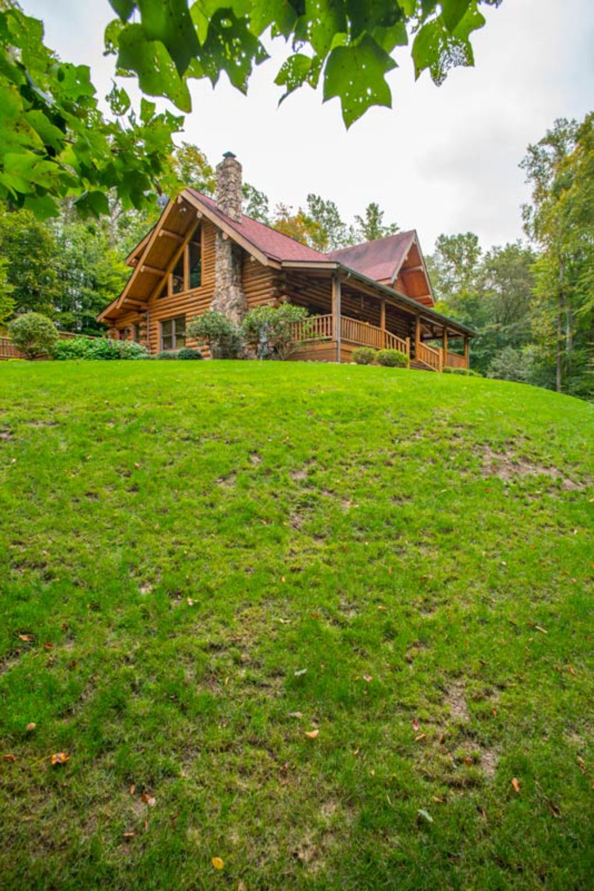 log cabin with trapezoid windows on wall on top of hill