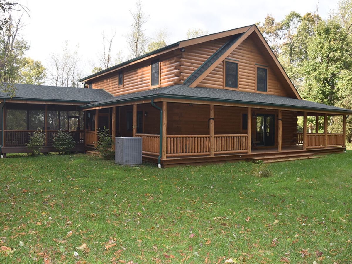 side of log cabin with extended screened porch
