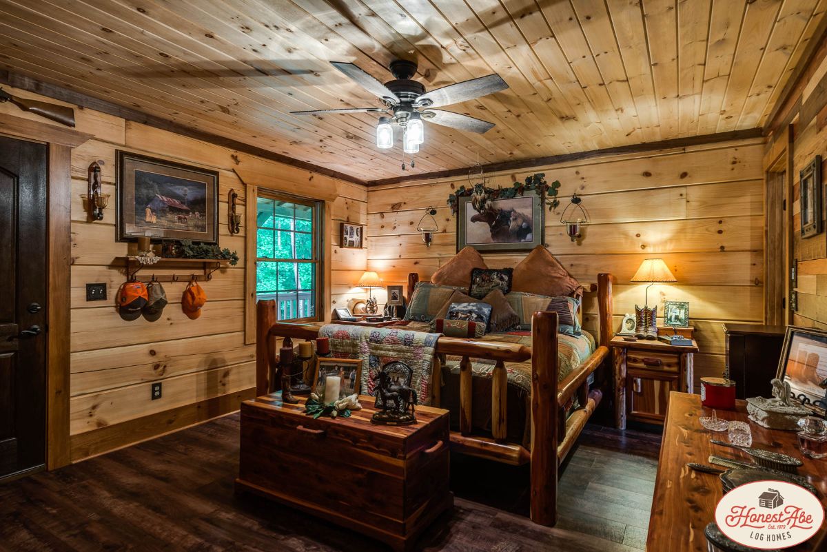 bed with wood bedframe against wall of log cabin