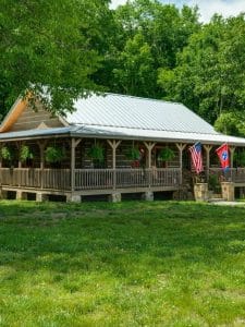 flags hanging off porch on log cabin