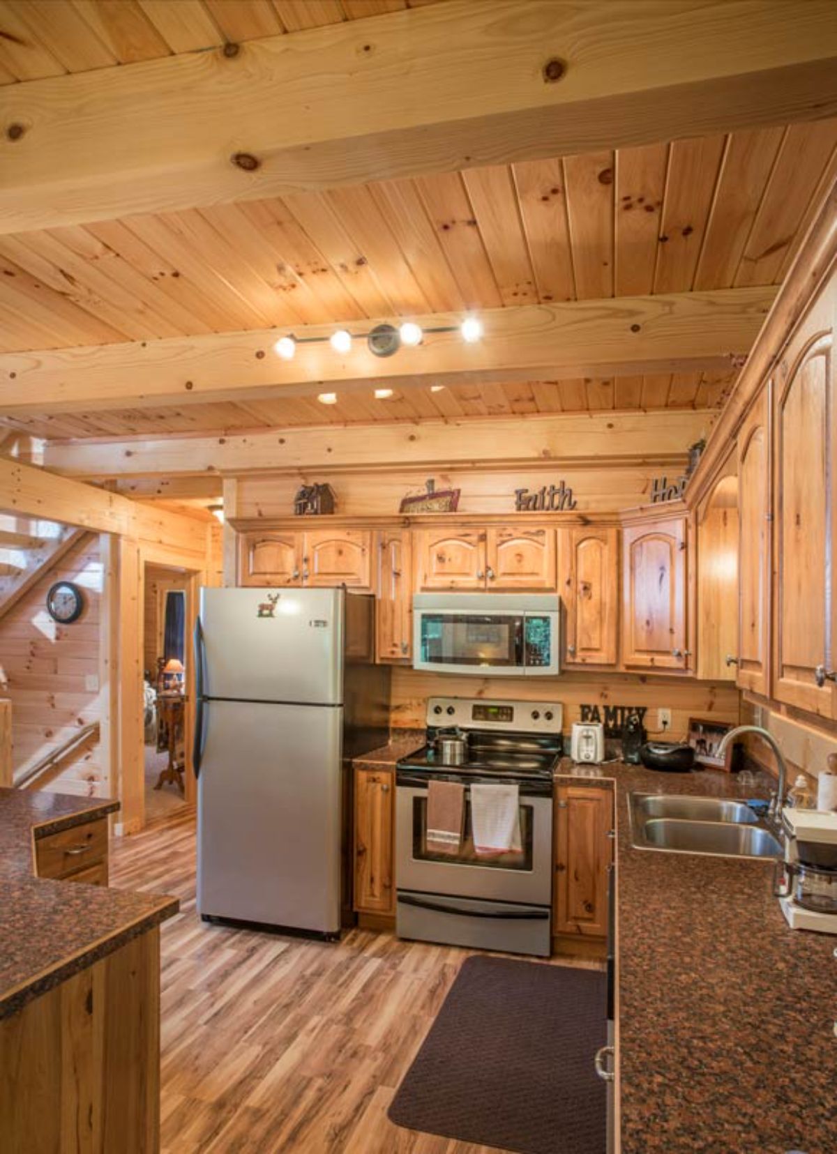 stainless steel refrigerator and stove against back wall of log cabin
